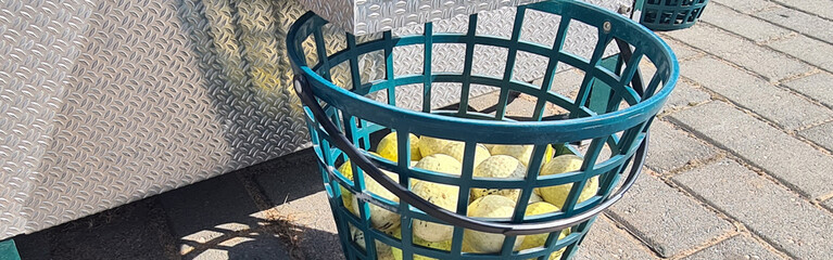 Golf machine pours balls into basket closeup