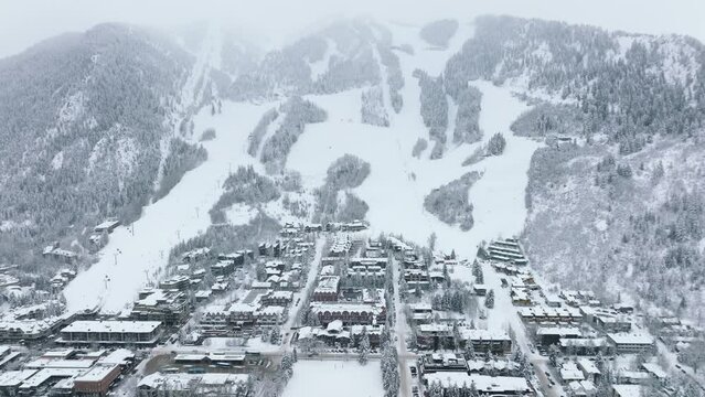 Aerial Aspen town view Mountain chalets in ski resort area with snowy slopes on winter day. Christmas holidays, winter travel vacation, people skiing. Winter Holidays in Aspen village in Colorado USA