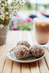 Healthy vegan handmade sweets - gluten and sugar free natural hedgehogs and coffee on the wooden table. Healthy dessert