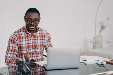 Puzzled african american man look at laptop screen. Poor internet connection. Problem at remote work