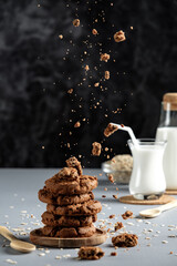 chocolate chip cookies and milk, motion freeze, food levitation, oatmeal cookies with crumbs and milk, on a black background