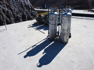 Welding oxygen cylinders cast long shadows at construction site. Welding construction equipment