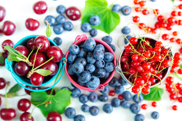Mix of fresh berries in small buckets. Juicy summer wallpaper.