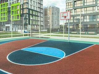 playground for basketball. anti-slip coating for a sports field made of rubberized material. on the court there is a ball ring. active recreation in the courtyard of a residential building