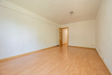 Empty living room with oak parquet flooring, plain white walls and oak woodwork