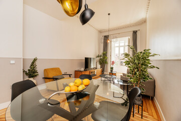 Living room with round glass dining table with ripe fruit centerpiece