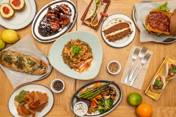 Plate set with delicious international recipes with carrot cake, grilled vegetable tray, chicken risotto, philadelphia sandwich, bao sandwiches, stuffed potatoes and burgers