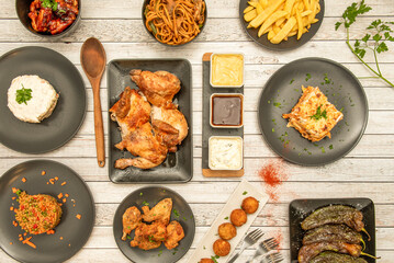 Plate set with delicious Spanish recipes for tapas and chips, fried green peppers, brias wings, rice with vegetables, croquettes, Russian salad, chopped roast chicken and sauces