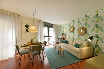 living room with reddish wooden floor, round wooden dining table with designer chairs upholstered in fabric, designer rattan lamp, metal mirror on the wall and breakfast with fresh fruits