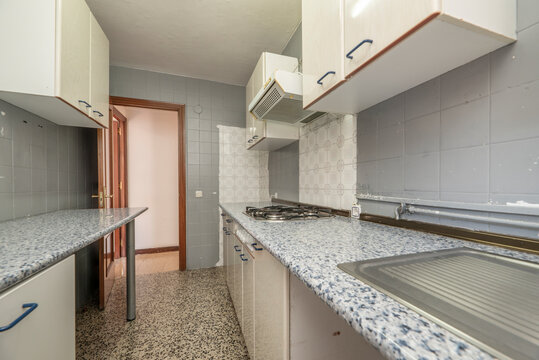 Kitchen With Old Wooden Furniture, Half Painted Walls, Similar Stone Countertop, And Terrazzo Floors