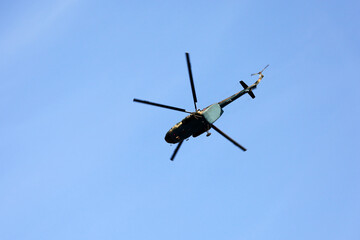Fototapeta na wymiar Russian military helicopter Mi-8 (NATO codification: Hip) in flight on blue sky background, bottom view