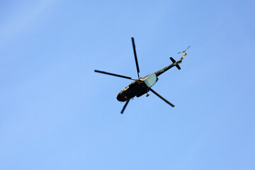 Russian military helicopter Mi-8 (NATO codification: Hip) in flight on blue sky background, bottom...