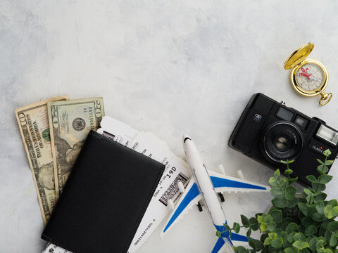 Travel planning - a small plane, money and tickets in a passport, a camera on a white background. Leisure, tourism, vacation, business. There is free space to insert.