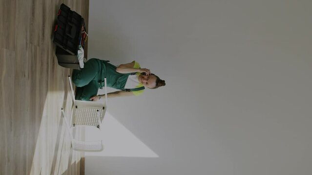 Female is assembling a chair. Vertical video
