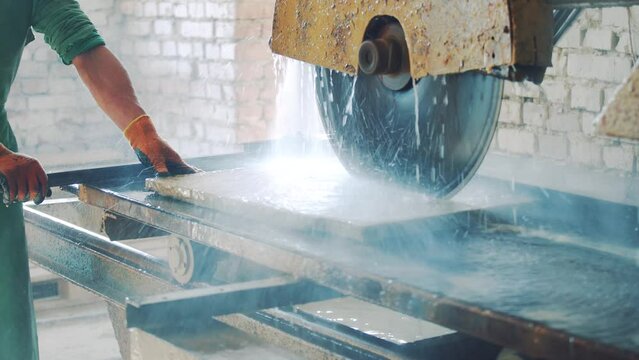 Cutting stone at the factory. Saw blade equipment sprays water on rock for cooling. Saw blade ror hard mineral cutting. Processing Equipment
