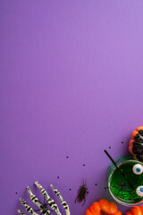 Halloween concept. Top view vertical photo of glass with green drink floating eyeball punch straw...