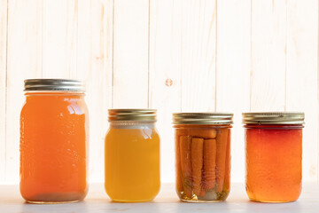 Jars of homemade canned goods against a bright white background with copy space