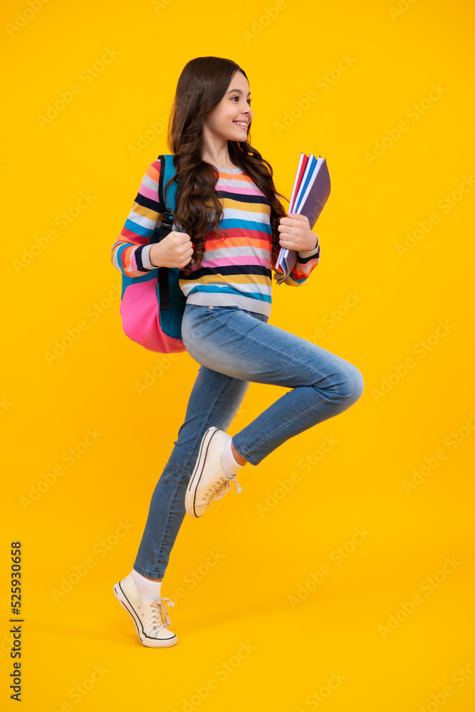 Canvas Prints school girl hold copybook and book on yellow isolated studio background. school and education concep