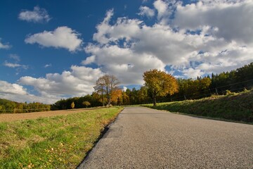 Fototapeta premium A road in a landscape with an arch full of clouds