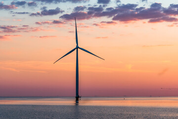 Wind turbine in the sea in the warm sunset light