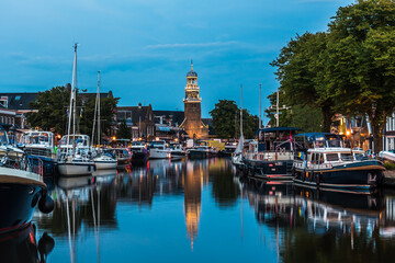 Fototapeta na wymiar View of the illuminated historical part of the city of Lemmer in Friesland, Netherlands after sunset