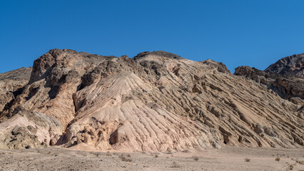 Eroded mountain in the Death Valley desert with a blue sky and copy space
