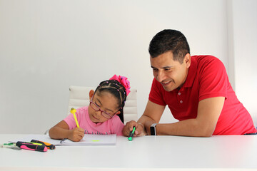 Latino dad and daughter, teacher and student draw in a notebook with colors in this back to school...