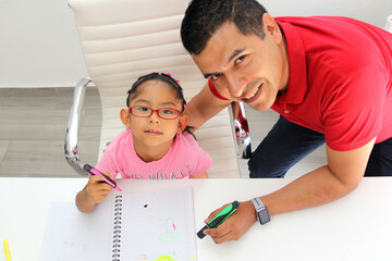 Latino dad and daughter, teacher and student draw in a notebook with colors in this back to school to improve skills with Autism Spectrum Disorder (ASD) - obrazy, fototapety, plakaty