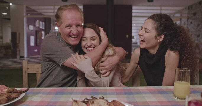 Younger daughter tells everyone at the dinner table positive news. Family congratulates girl the good news. Group of people celebrate announcement at home backyard celebration