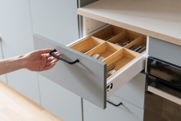 hand open cutlery drawer at contemporary kitchen - obrazy, fototapety, plakaty