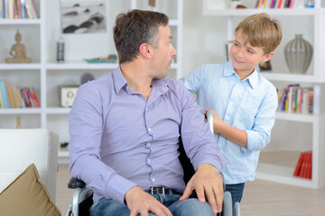 Fototapeta premium dad in a wheelchair with his son