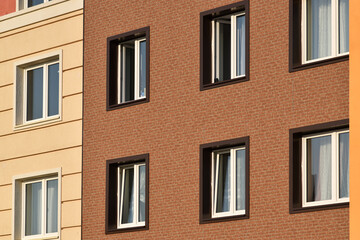 Fototapeta na wymiar A close-up of the windows of a residential building with beautiful windows is a new multi-apartment residential quarter of European houses.