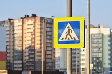 A road sign warns a pedestrian against the background of houses