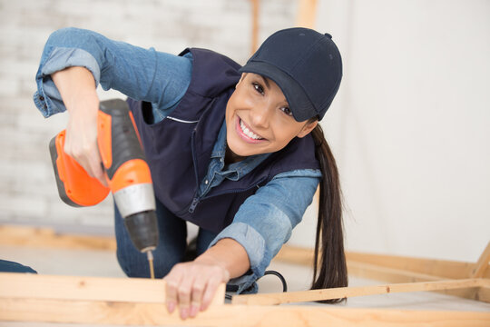 female carpenter using electric drill