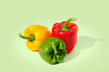 Yellow, red, green pepper on green background