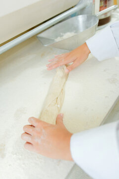 a female chef rolling dough