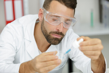 scientist or medical in lab coat holding test tube