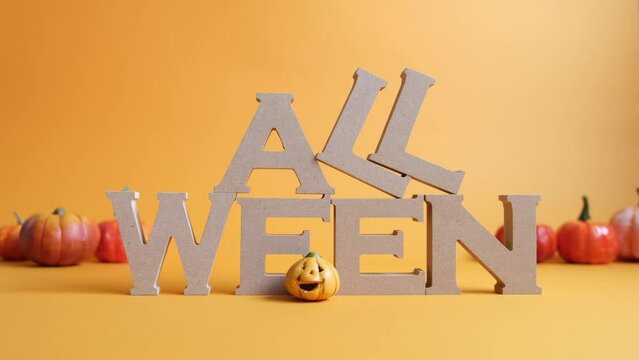 ハロウィンの文字のHとOの文字を手で置くオレンジ背景の動画