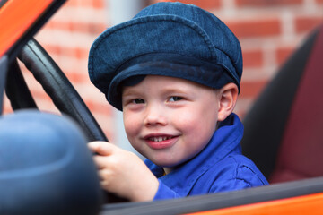 Big Dream of a Little Boy / Cute little rascal child sitting in dads car on steering wheel and plays driving - 525940859