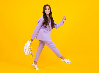 Fototapeta na wymiar Back to school. Fashion teenage school girl ready to learn. School children on yellow isolated background. Run and jump. Happy face, positive and smiling emotions of teenager girl.