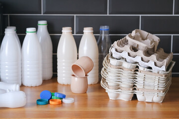 plastic waste collected and prepared for recycling, plastic milk bottles, caps and egg carton boxes on the kitchen