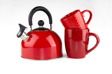 Red whistling kettle with two red mugs on a white background.
