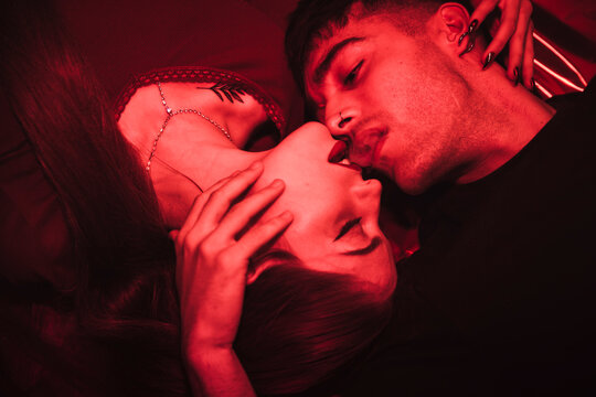 Couple passing the smoke of a joint with their lips