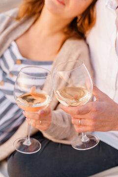 Glasses With Wine In Hands With Wedding Rings Of Young Couple In