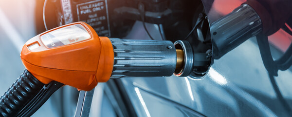 Close-up detail view of fuel autogas pump gun connected with noozle adapter to car tank to refill...