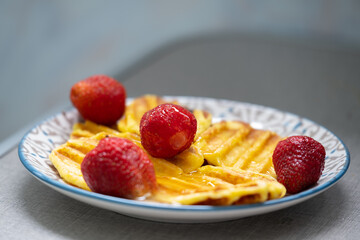 Cottage cheese pancakes with red fresh strawberries on a plate
