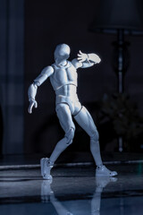 Fototapeta na wymiar Standing male figurine raising arm blocking bright light from face.