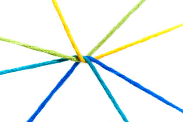 Yellow, green, blue, teal, yarn intertwined and radiating outward on a white background.