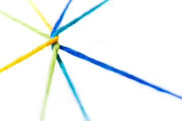 Yellow, green, blue, teal, yarn intertwined and radiating outward on a white background.