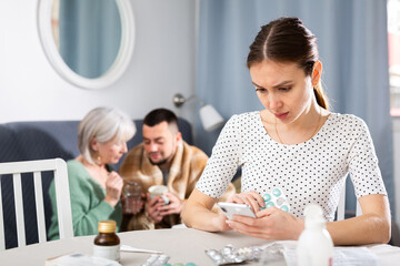 Fototapeta premium Young wife carefully reads the annotation for medicines and checks the information on the Internet